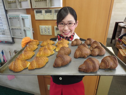 焼きたてパンを持ちあげているスタッフ